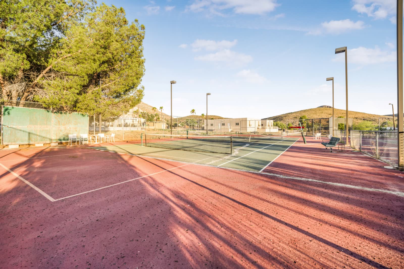 Existing fenced tennis courts with mountain views